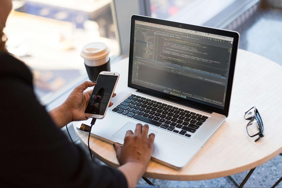person looking at phone while coding