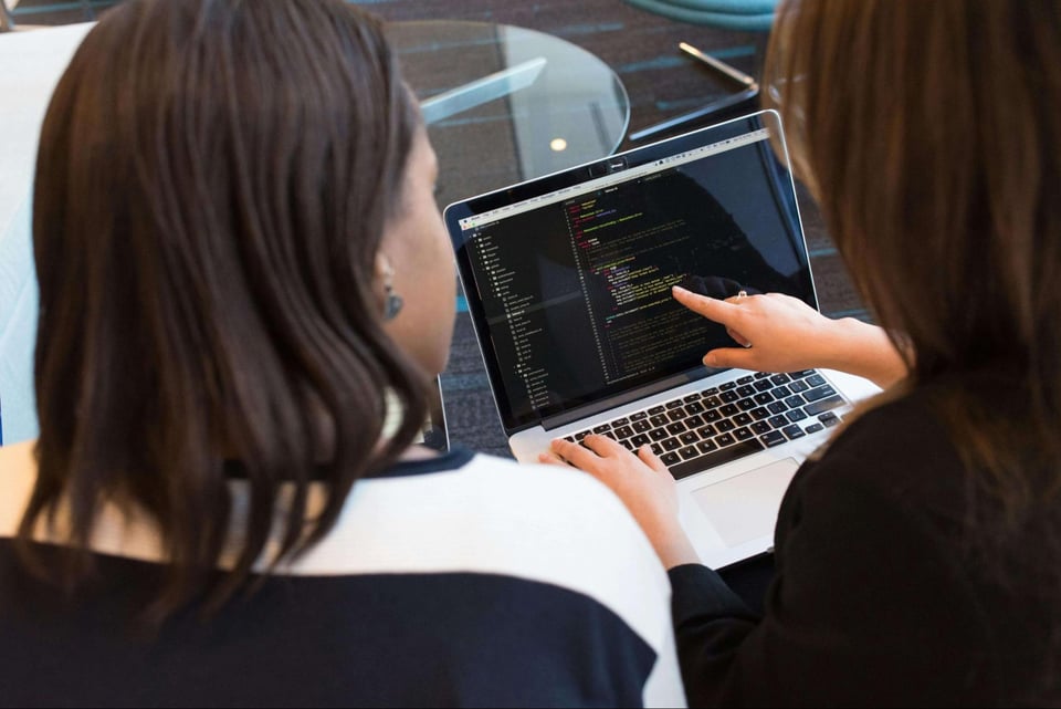 two people coding on laptop