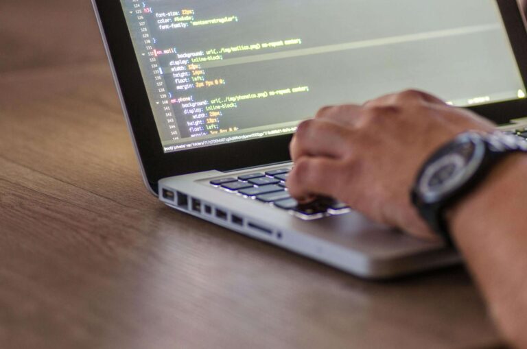 person coding on laptop