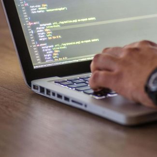 person coding on laptop