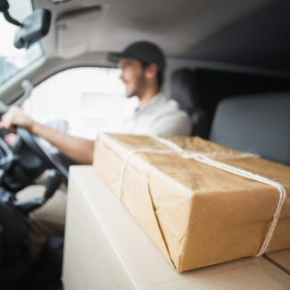 Delivery,Driver,Driving,Van,With,Parcels,On,Seat,Outside,The